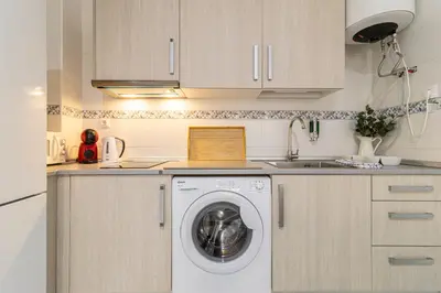 a kitchen with a washing machine and a sink at Allo Apartments San Lucas Parking Piscina Centro 2 habitaciones in Jerez de la Frontera