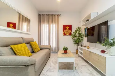 a living room with a couch and a tv at Allo Apartments San Lucas Parking Piscina Centro 2 habitaciones in Jerez de la Frontera