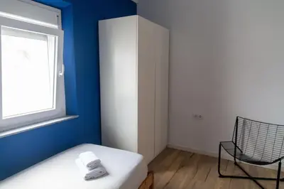 a room with a bed and a window and a chair at El Ático de la Palma by Gades Gestión in Cádiz