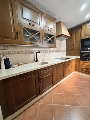 a kitchen with wooden cabinets and a sink at Casa Azacanes in Sanlúcar de Barrameda