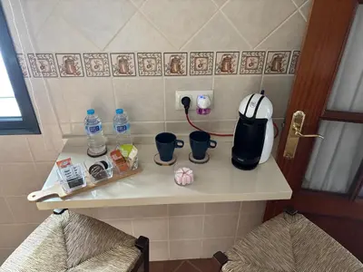 a kitchen counter with a coffee maker and two chairs at Casa Azacanes in Sanlúcar de Barrameda