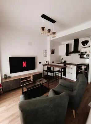 a living room with a tv and a dining room at Amber Suite in Jerez de la Frontera