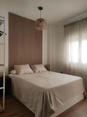 a bedroom with a large white bed with a chandelier at Amber Suite in Jerez de la Frontera