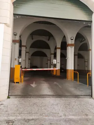 an empty parking garage with orange chairs and a barrier at Amber Suite in Jerez de la Frontera