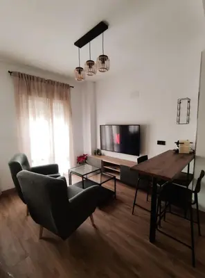a living room with a table and chairs and a television at Amber Suite in Jerez de la Frontera