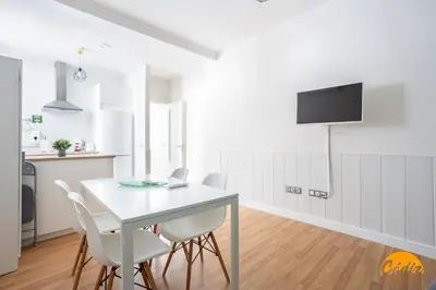 a kitchen and dining room with a white table and chairs at Apartamento El Patio by Cadiz Time in Cádiz