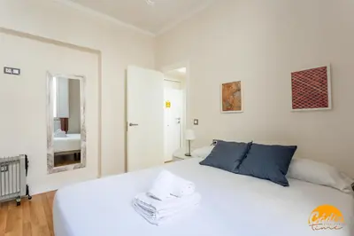 a white bedroom with a white bed and a mirror at Apartamento El Patio by Cadiz Time in Cádiz