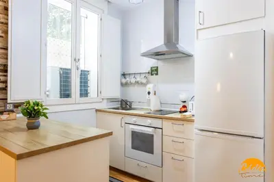 a kitchen with white cabinets and a white refrigerator at Apartamento El Patio by Cadiz Time in Cádiz