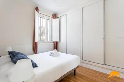 a bedroom with a white bed and a window at Apartamento El Patio by Cadiz Time in Cádiz