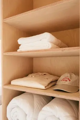 a closet with white folded towels and a hat at wecamp Cádiz in Cádiz
