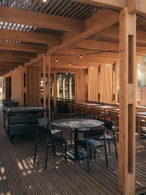 a patio with tables and chairs on a wooden deck at wecamp Cádiz in Cádiz