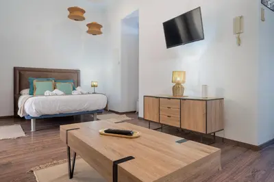 a bedroom with a bed and a table and a tv at Panther Home Aladro II in Jerez de la Frontera