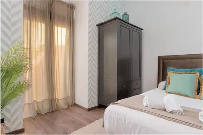 a bedroom with a bed with a cabinet and a window at Panther Home Aladro II in Jerez de la Frontera