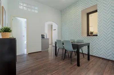 a dining room with a black table and blue chairs at Panther Home Aladro II in Jerez de la Frontera