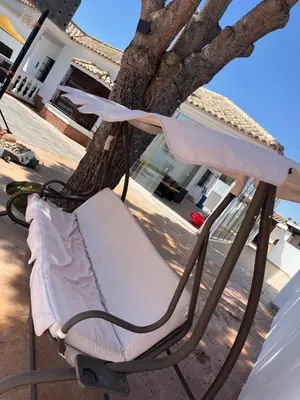 a chair on a porch next to a tree at Rincón del mar in Novo Sancti Petri