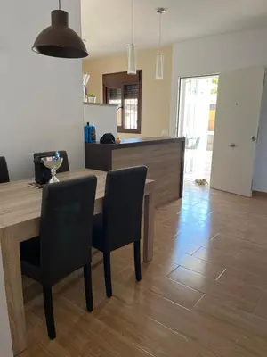 a kitchen and dining room with a wooden table and chairs at Rincón del mar in Novo Sancti Petri
