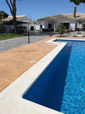 a swimming pool with blue water in front of a house at Rincón del mar in Novo Sancti Petri