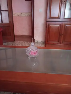a glass bowl with pink flowers in it on a table at Como en casa in Jerez de la Frontera
