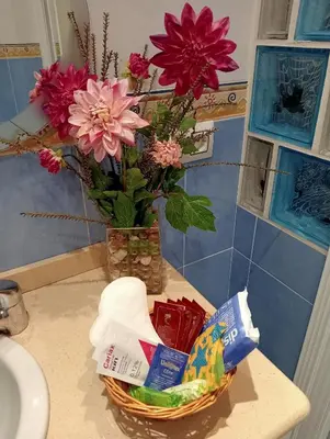 a basket of flowers on a counter next to a sink at Como en casa in Jerez de la Frontera