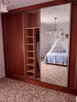 a bedroom with a bed and a large glass door at Como en casa in Jerez de la Frontera