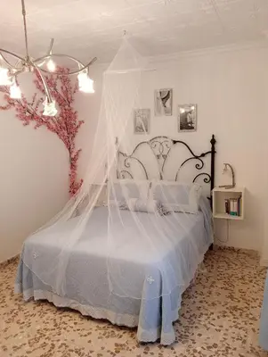 a bedroom with a bed with a canopy at Como en casa in Jerez de la Frontera