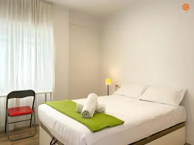 a bedroom with a white bed with a red chair at Mar de Viya Grupo AC Gestion in Cádiz