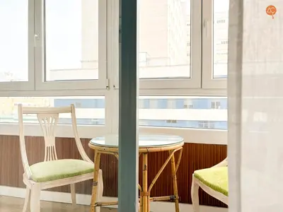a table and two chairs in a room with windows at Mar de Viya Grupo AC Gestion in Cádiz
