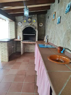a kitchen with a counter top with a fireplace at Encantador chalet con piscina in Conil de la Frontera