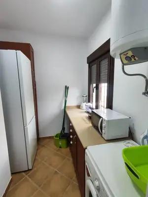 a kitchen with a white refrigerator and a microwave at Encantador chalet con piscina in Conil de la Frontera