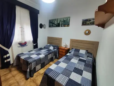 two beds in a room with blue and white at Encantador chalet con piscina in Conil de la Frontera