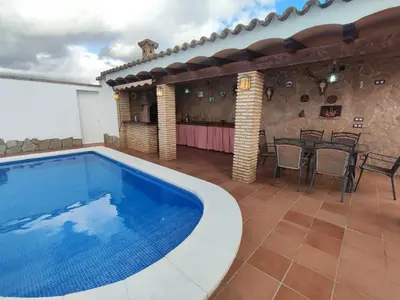 a swimming pool in a patio with a table and chairs at Encantador chalet con piscina in Conil de la Frontera
