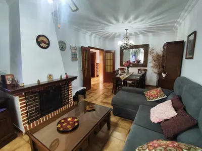 a living room with a couch and a fireplace at Encantador chalet con piscina in Conil de la Frontera