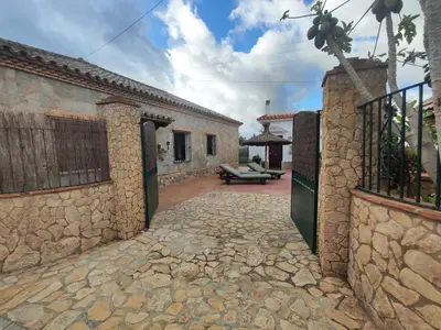 a stone alleyway leading to a patio in a house at Encantador chalet con piscina in Conil de la Frontera