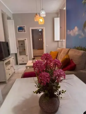 a living room with a vase with purple flowers on a table at Casa Palacio en Casco Antiguo in El Puerto de Santa María