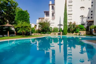 an empty swimming pool with buildings in the background at MasApartamentos El Puerto in El Puerto de Santa María
