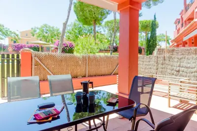 a patio with a glass table and chairs on a balcony at MasApartamentos El Puerto in El Puerto de Santa María