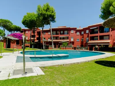 a swimming pool in front of a building at MasApartamentos El Puerto in El Puerto de Santa María
