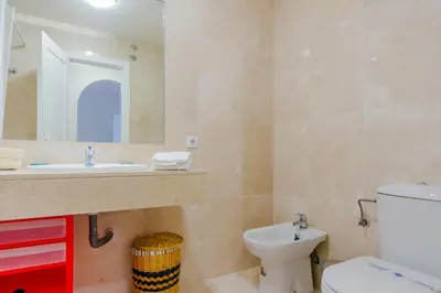 a bathroom with a sink and a toilet and a mirror at MasApartamentos El Puerto in El Puerto de Santa María