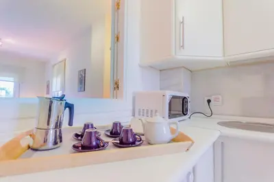 a kitchen with a counter top with a blender and cups at MasApartamentos El Puerto in El Puerto de Santa María