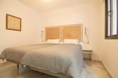 a bedroom with a large bed and a window at Apartamento Vistahermosa terraza y piscina in El Puerto de Santa María