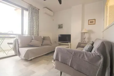 a living room with a couch and a tv at Apartamento Vistahermosa terraza y piscina in El Puerto de Santa María