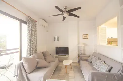 a living room with a couch and a ceiling fan at Apartamento Vistahermosa terraza y piscina in El Puerto de Santa María