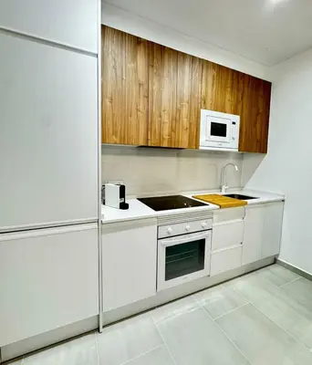 a white kitchen with a sink and a microwave at Apartamentos Muñoz Fornell 4 in Chiclana de la Frontera
