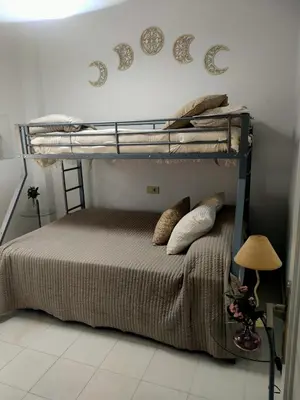 a bedroom with two bunk beds and a lamp at Ático primera línea en costa ballena in Rota