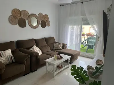 a living room with a couch and a table at Ático primera línea en costa ballena in Rota