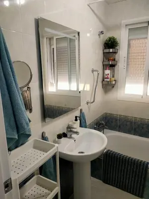 a bathroom with a sink and a mirror and a tub at Ático primera línea en costa ballena in Rota