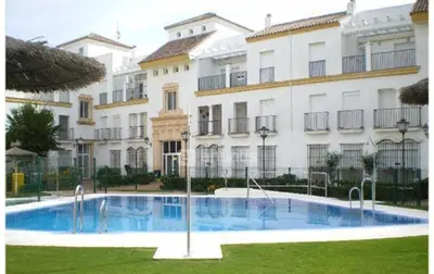 a swimming pool in front of a building at Ático primera línea en costa ballena in Rota