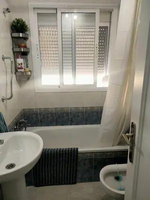 a bathroom with a tub and a sink and a window at Ático primera línea en costa ballena in Rota