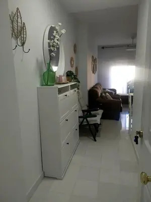 a room with a dresser with a mirror and a couch at Ático primera línea en costa ballena in Rota