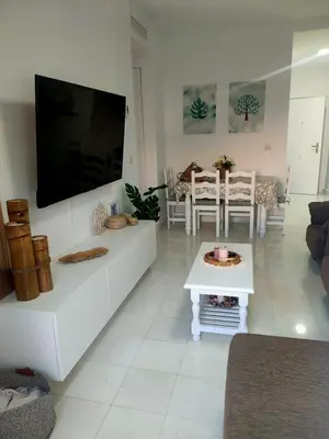 a living room with a large flat screen tv on the wall at Ático primera línea en costa ballena in Rota